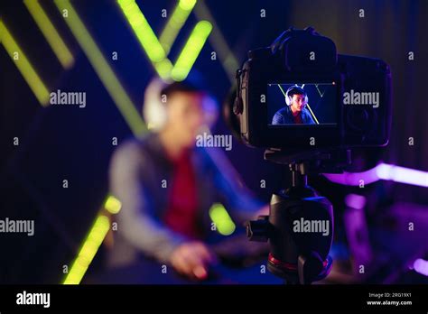 Live streaming to an online audience, a young man sits in front of a ...