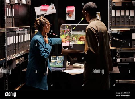 Police detective partners analyzing clues scheme on detective board ...