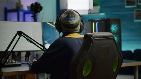 Back shot of pro gamer woman playing first person games using RGB ...