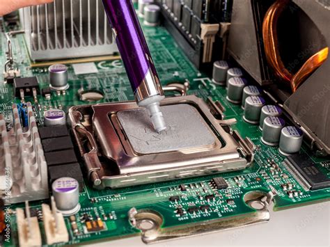 Application of thermal paste from a special syringe to the CPU cover ...