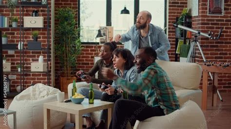 Diverse people playing video games online on console, using controller ...