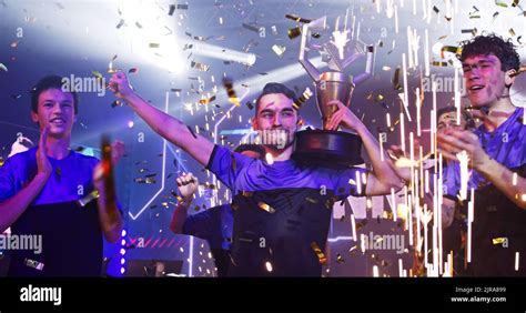 Esport gamers team with golden trophy celebrating victory amidst ...