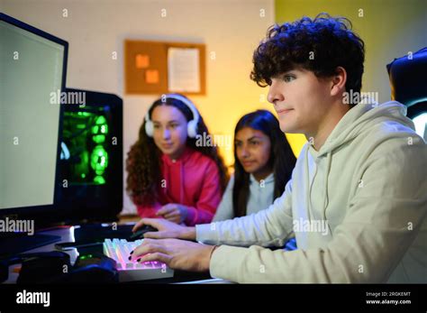 Side view of focused young male gamer looking at screen of monitor ...