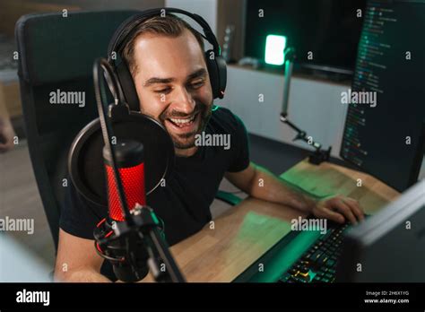 Happy young man gamer streamer in headphones playing on computer ...