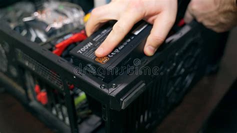 Installing the Power Supply in the System Unit Case. Hands of a Man ...